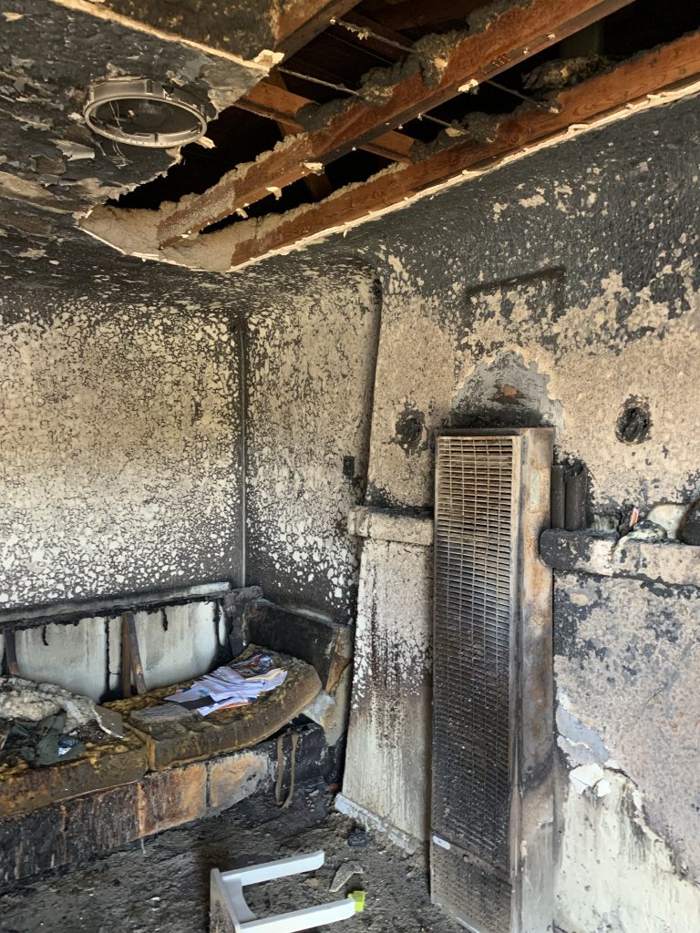 a room with a burnt wall and a couch