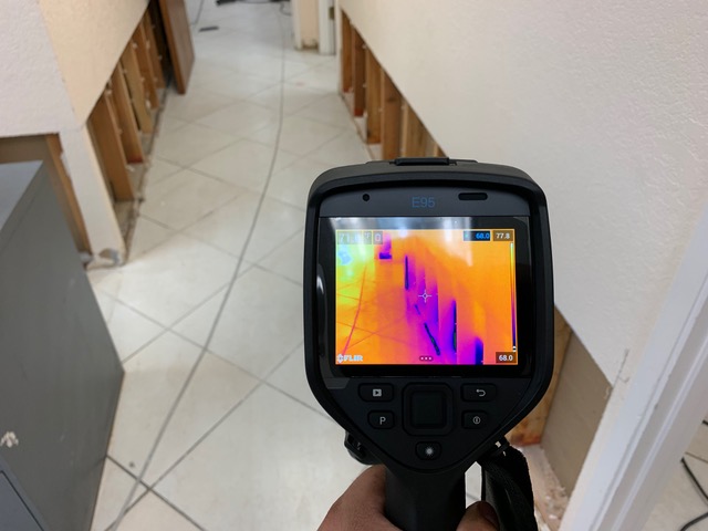 a hand holding a thermal imaging camera